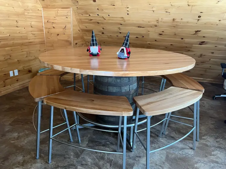 Table ronde et bancs cintrés en acier, montés autour d’un baril
